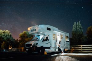 Un camper con due persone sotto un cielo stellato