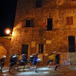 Atleti che corrono in un borgo toscano