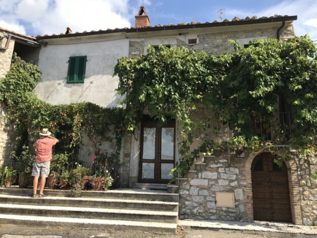 Un turista che fotografa il pergolato di un'abitazione a Rocchette di Fazio