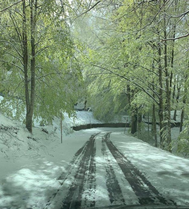 Neve sulla strada di montagna in una giornata di primavera