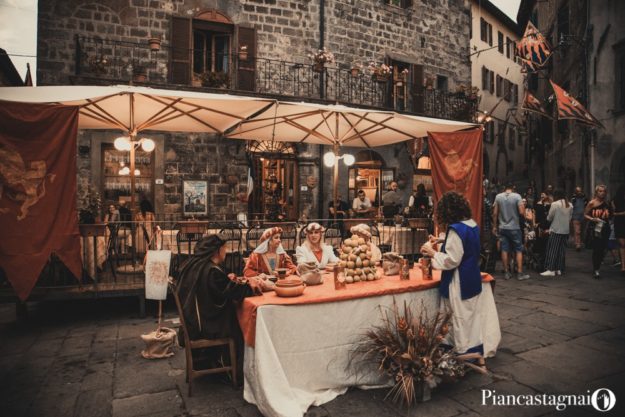 donne in costumi storici che siedono in una piazza di Piancastagnaio, durante un evento