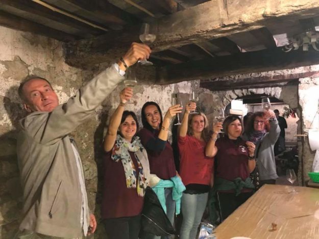 Uomini e donne insieme per un brindisi dentro ua cantina